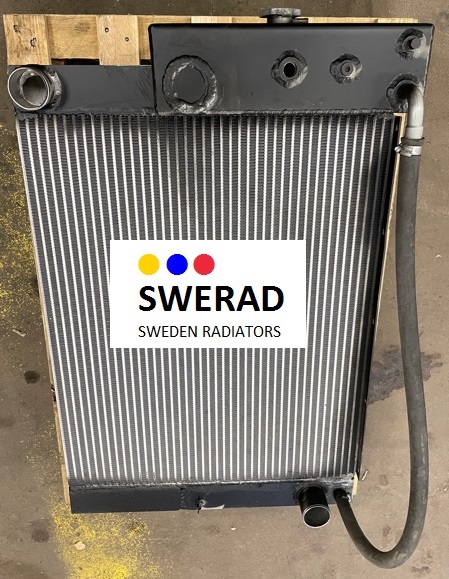 Kylare Kiruna, en metallradiator med texten "SWERAD SWEDEN RADIATORS" på en vit etikett med tre färgade prickar (gula, blå, röda) och påsatta slangar, ligger på en träpall.