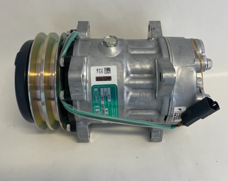 En Värmeelement Dodge cylindrisk metallisk bildel med kablar och flera anslutningsportar placerade på en vanlig bakgrund.