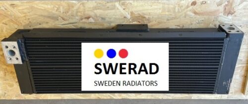 En svart kylare märkt "Kylare Mitsubhishi truck" med orden "SWERAD" och "SWEDEN RADIATORS", med gula, blå och röda prickar, är monterad på en träbakgrund.